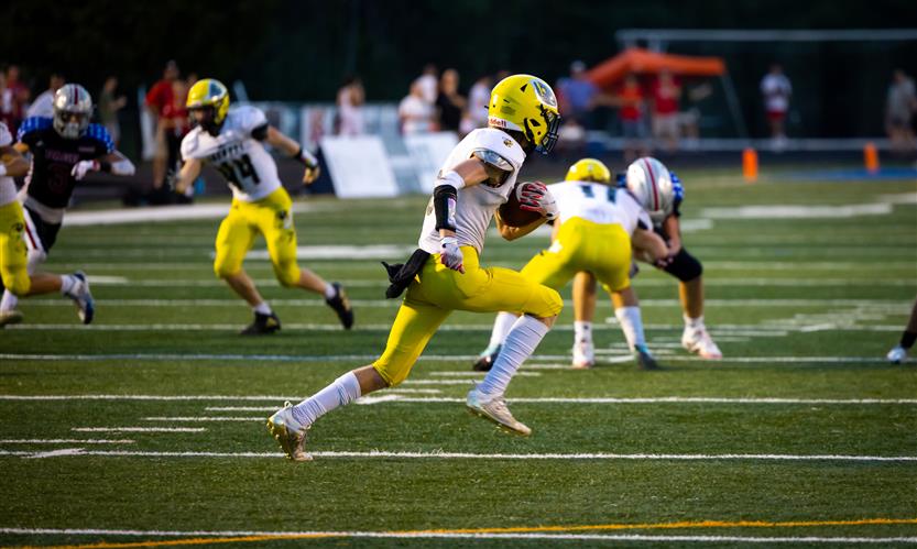 A football player runs the ball